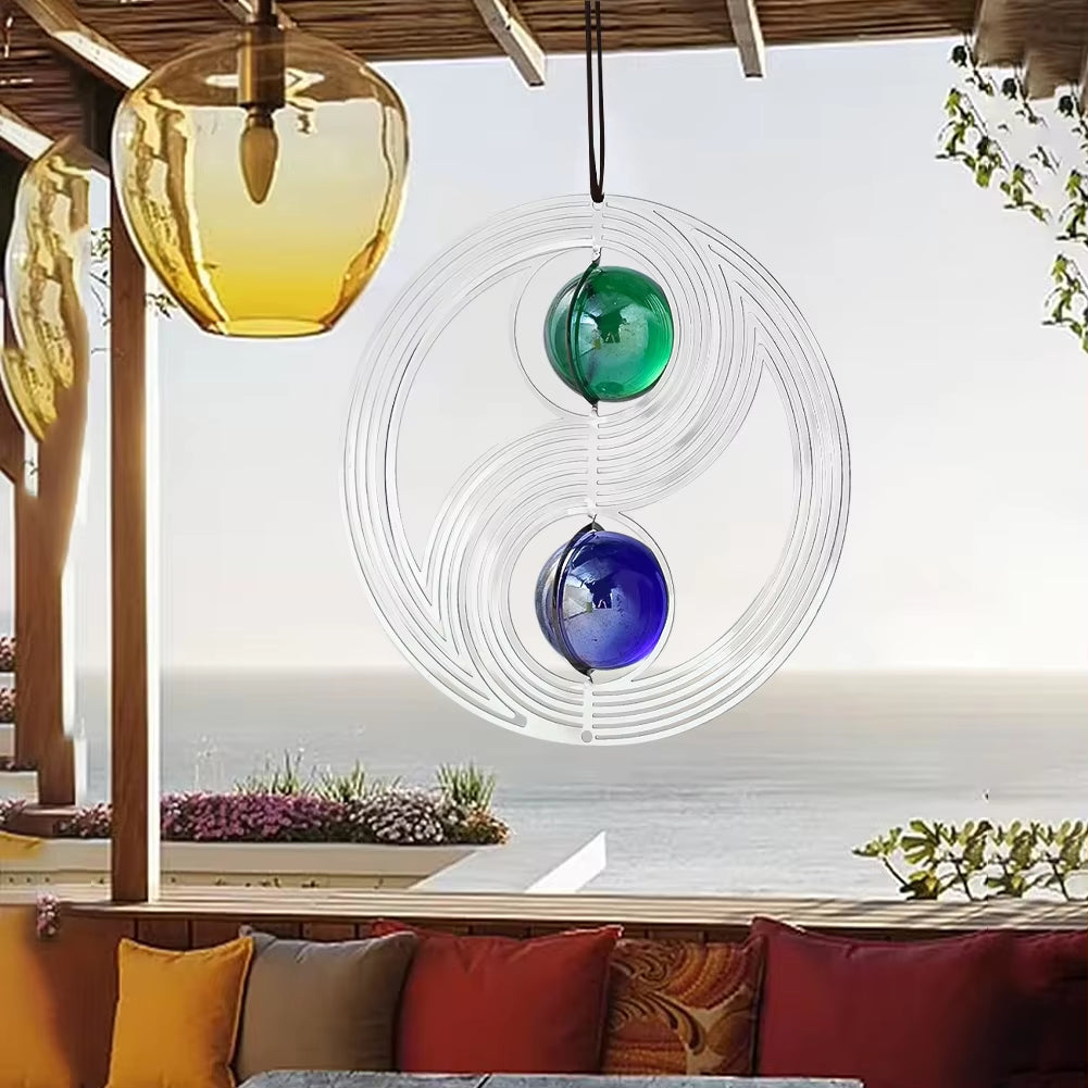 Circular glass wind spinner with blue and green marbles in yin-yang pattern for garden